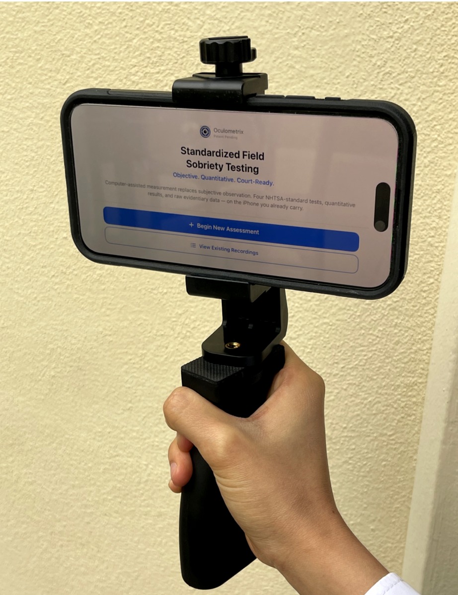 Oculometrix device — iPhone in tactical grip held by officer in the field